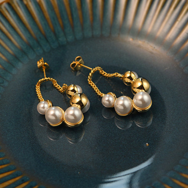 Sparkling Pearl Earrings, with golden chain. The earring backing is set with 3 different sized faux pearls on the front and 2 different sized ones on the reverse backing. When wearing the earrings, the luster of the pearls can be seen on both the front and back.