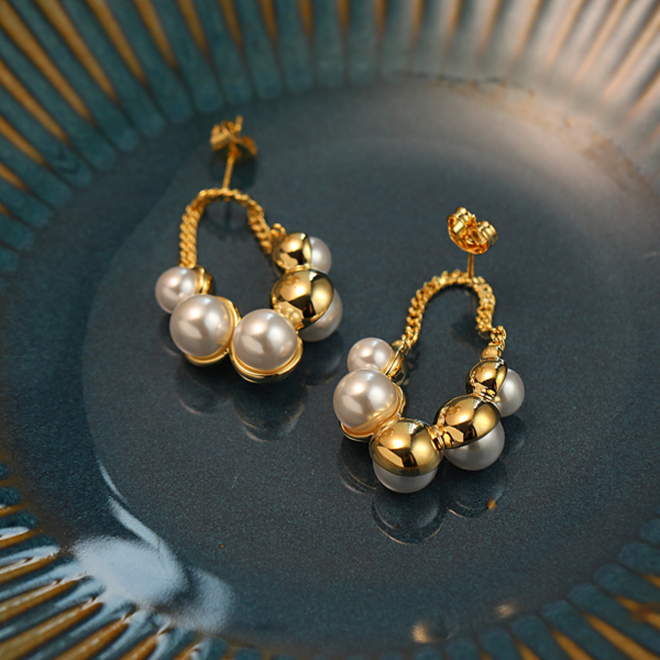 Sparkling Pearl Earrings, with golden chain. The earring backing is set with 3 different sized faux pearls on the front and 2 different sized ones on the reverse backing. When wearing the earrings, the luster of the pearls can be seen on both the front and back.