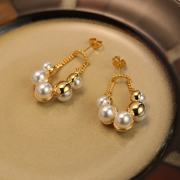 Sparkling Pearl Earrings, with golden chain. The earring backing is set with 3 different sized faux pearls on the front and 2 different sized ones on the reverse backing. When wearing the earrings, the luster of the pearls can be seen on both the front and back.