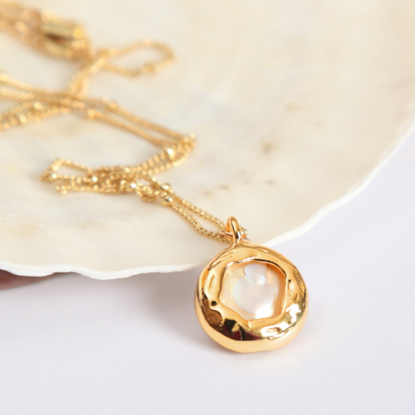 Simple Baroque Freshwater Pearl Button Necklace, the necklace pendant is a round button baroque pearl wrapped in a gold alloy exterior.