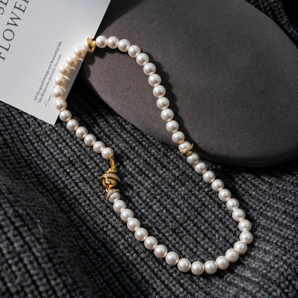 Premium Simplicity Pearl Spiral Collarbone Necklace, artificial pearl. There are 2 artificial pearls half-wrapped in rose gold metal, and the necklace is connected by a magnet with a circle of small diamonds wrapped around the outside.