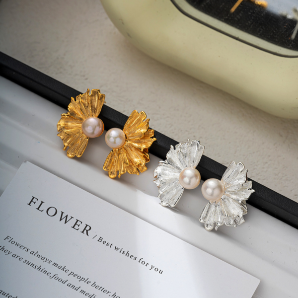 Natural pearl French floral textured earrings, golden and silver color, fan shape. The earrings have a natural freshwater pearl set in the center, and the left and right earrings each have the shape of a half-flower made of alloy, available in gold and silver color.