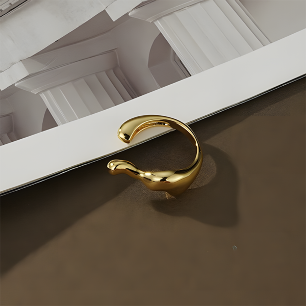 Elegant Streamline Split Ring - Golden Color, the shape like steam. This ring features a sleek, modern design characterized by its unique wavy shape. Crafted in a shiny gold finish, it showcases a combination of smooth and sculptural elements, giving it a contemporary feel. The open band allows for an adjustable fit, making it both stylish and comfortable for everyday wear. This eye-catching piece is perfect for adding a touch of elegance and artistic flair to any outfit.